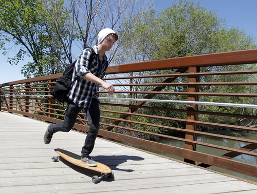 Al Hartmann  |  The Salt Lake Tribune 
A skateborder crosses the Jordan RIver on a bridge at 1800 North Redwood Road to access one of the last sections of the Jordan River Parkway Trail to be completed .