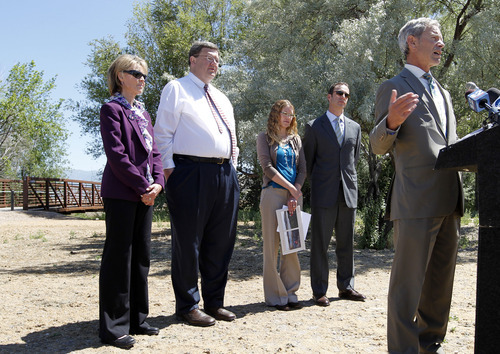 Al Hartmann  |  The Salt Lake Tribune 
Mayor Ralph Becker, right, speaks at celebration of the completion of one the last sections of the Jordan River Parkway Trail at 1800 N. Redwood Road on Thursday June 7, 2012. Davis County Commissioner Louenda Downs, left back row,  Salt Lake City Councilman Carlton Christensen, Jordan River Commission Executive Director Laura Hanson, and Wasatch Front Regional Council Executive Director Andrew Gruber aslo spoke.  
The new section of Jordan River Parkway trail extends one mile from Redwood Road at approximately 1800 North, to the Davis County line and includes a 10-foot-wide asphalt trail, 5-foot- wide horse trail and 1,000 feet of elevated boardwalk through a wetlands area.
