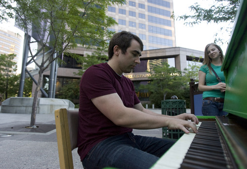 Kim Raff | The Salt Lake Tribune
Erin Page watches as Doug Vandegrift plays a piano installed at the Gallivan Center downtown as part of Utah Museum of Contemporary Art's  