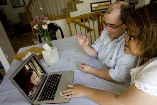 Kim Raff | The Salt Lake Tribune
Jhan and Farah Jensen video-chat with their adopted daughter Miriam at their home in Roy on June 2, 2012. The Jensens adopted Miriam from Malaysia, but after a bunch of red tape from both governments, she has already celebrated her first birthday in Malaysia while the Jensen family awaits in Utah to have her come live with them.
