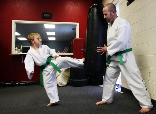Kim Raff | The Salt Lake Tribune
Dov Siporin holds the bag for his son, Matan, while warming up for his  lesson at Salt Lake Valley Tae Kwon Do Academy in Salt Lake City.