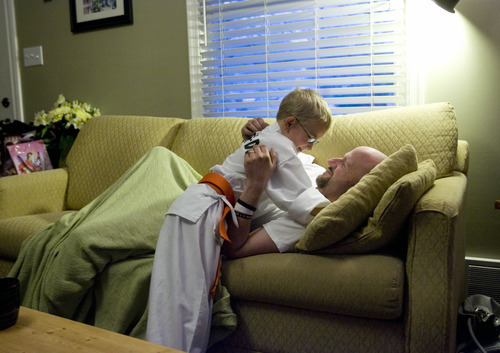Kim Raff  |  The Salt Lake Tribune
After a day spent mostly on the sofa in pain from chemotherapy treatment, Dov Siporin receives a hug from his son, Matan. Siporin has terminal colon cancer. His children have spent most of their lives with their father ill and help to comfort him during the days he is most sick.