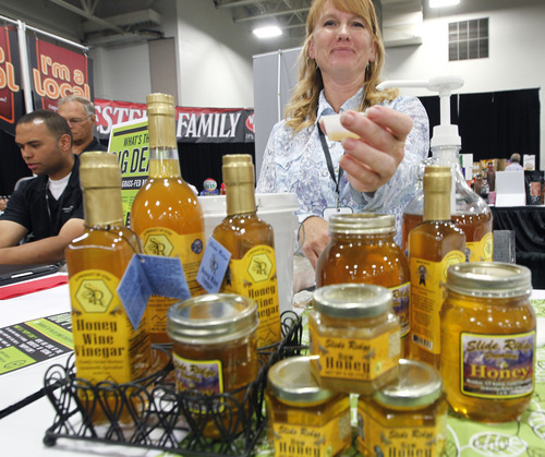 Al Hartmann  |  The Salt Lake Tribune
Keli Bess of Slide Ridge Honey located in Mendon Utah pours a sample of honey wine vinegar to taste at the Associated Food Stores Food Show 2012 at the Salt Palace Convention Center Wednesday June 20.  The business makes honey, honey wine vinegar and wine.     The food show includes Utah grown and manufactured products to be seen by  400 grocers doing business in eight states.