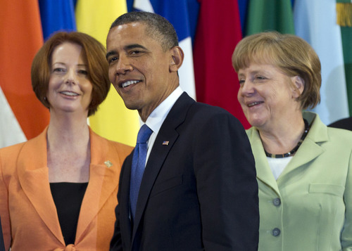 President Barack Obama, center, takes his place with other leaders, including Australian Prime Minister Julia Gillard, left, and German Chancellor Angela Merkel, for the Family Photo during the G20 Summit, Monday, June 18, 2012, in Los Cabos, Mexico. (AP Photo/Carolyn Kaster)