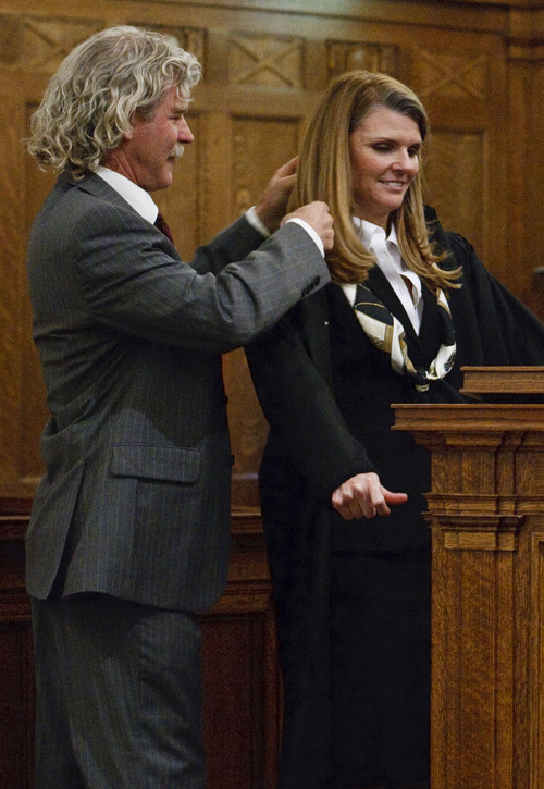 Leah Hogsten  |  The Salt Lake Tribune
Evelyn J. Furse is helped into her U.S. Magistrate Judge robe by her husband Rusty Dassing after swearing the oath of office. Evelyn J. Furse became the newest magistrate judge for the U.S. District Court for Utah Friday, June 22, 2012 in Salt Lake City. Furse was a senior attorney for Salt Lake City Corp., where among other things she defended the city's proposed soccer complex bond, before being nominated to fill the position vacated by new federal Judge David Nuffer. Before joining the city, Furse clerked for Utah Supreme Court Justice Christine Durham and then worked for several local law firms. She is a past president of the Women Lawyers of Utah and chaired its Initiative on the Advancement and Retention of Women Attorneys. Furse graduated with a bachelor's degree in public policy analysis from the University of North Carolina in 1993. She attended law school at New York University School of Law in 1996. Magistrate judges conduct preliminary hearings in criminal cases and also handle other criminal and civil matters as assigned by district judges.