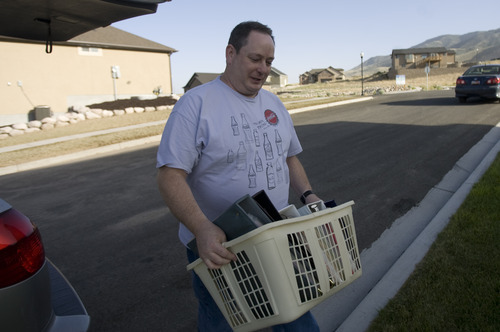 Kim Raff | The Salt Lake Tribune
Lynn Chaffin bring photo albums back into his home after being able to return to his home in the Jacob Ranch subdivision after being evacuated from the Dump Wildfire in Saratoga Springs, Utah on June 23, 2012.