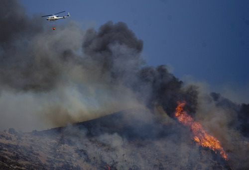 Kim Raff | The Salt Lake Tribune
Helicopters try to contain the Dump Wildfire in Saratoga Springs-Eagle Mountain area in Eagle Mountain, Utah on June 23, 2012.