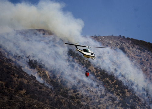 Kim Raff | The Salt Lake Tribune
Helicopters try to contain the Dump Wildfire in Saratoga Springs-Eagle Mountain area in Eagle Mountain, Utah on June 23, 2012.