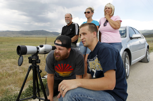 Al Hartmann  |  The Salt Lake Tribune  
Jed Buys, left, and his brother Jordan share a look through a spotting scope to look at the family's burned cabin high on the mountain near Indianola.  Craig, Cassie and Cindy Buys behind them reflect on the good times they had in the cabin.  It was one of eight cabins in the Indian Ridge homeowners assoication that burned in the Wood Hollow fire.  The family built the cabin together in 2001.  It was their first look at the damage.  All that's let is the foundation.  