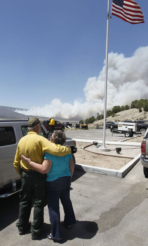 Al Hartmann  |  The Salt Lake Tribune  
Janice Taylor gets a hug of comfort from Indianola Fire Chief Kent Higgins as they watch the Wood Hollow fire flare up Tuesday, June 26, 2012, afternoon due to high winds.  The fire closed U.S Highway 89 further to the north about 2:30.  Janice Taylor and her husband David lost their home to the fire on Sunday.