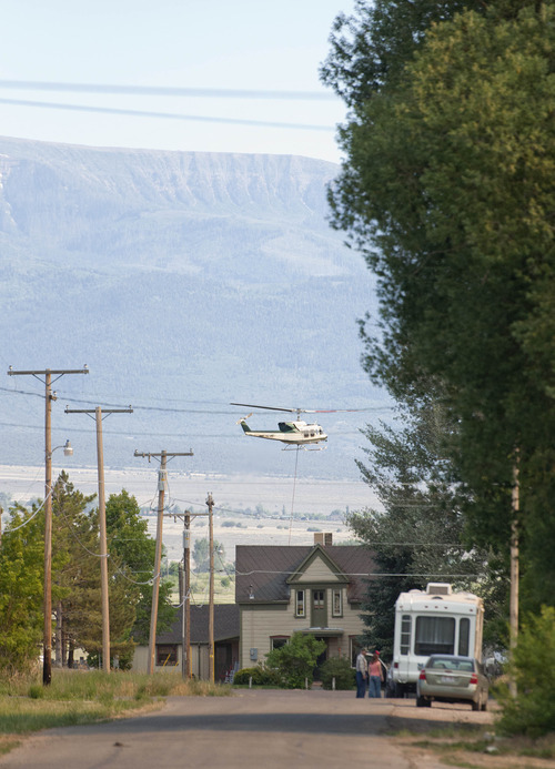 Michael Mangum  |  Special to the Tribune

A helicopter lowers a bucket to fill with water as residents of the town of Fairview load up their cars after having been given an evacuation order due to proximity of the Wood Hollow fire in Sanpete county on Tuesday, June 26, 2012.