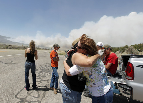 Al Hartmann  |  The Salt Lake Tribune  
Eva Richardson, left, hugs her siter-in-law Karin Johnstone and wishes her good luck as they wait on U.S Highway 89 near the Indianola firestation as the Wood Hollow fire blows up Tuesday, June 26, 2012.  Richardson lost her cabin on the Oquirrh Hills property west of the highway.  Jonestone's house is on the east side of highway 89 and was in danger as the fire blows eastward.  U.S Highway 89 was in danger of being closed again with the quickly moving fire moving to the east.