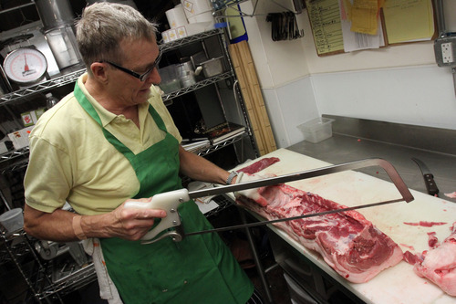 Francisco Kjolseth  |  The Salt Lake Tribune
Wielding tools of the trade, Frody Volgger is the man behind Caputo's market and deli's new butcher shop inside its downtown store. This long-time Utah chef recently battled colon cancer and had to close his restaurant, Vienna Bistro. But now he is back, butchering whole pigs and lambs and making fresh sausages, smoked hams and, his specialty, speck (smoked proscuitto).