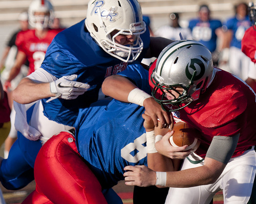 Michael Mangum  |  Special to the Tribune
Fremont defensive lineman Jake Gallegos, left, and Granger defensive lineman Elmer Pauni, 8, combine to sack Olympus quarterback Scott Porter during the first half of play of the Utah High School Coaches Association 4A/5A all-star football game at Alta High Schoolin June.