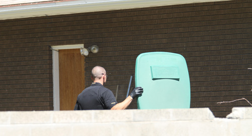 Lennie Mahler  |  The Salt Lake Tribune
Police search a garbage can in a backyard as they investigate the neighborhood near a canal where the body of a 6-year-old was found Tuesday, June 26, 2012.