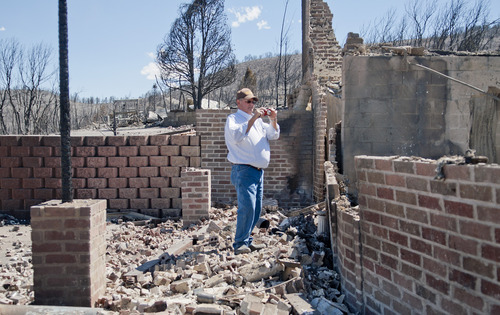 Michael Mangum  |  Special to the Tribune

Indianola resident Dave Taylor takes photos of what is left of his home in Sanpete county on Wednesday, June 27, 2012. The Wood Hollow wildfire ripped through the are earlier in the week and completely destroyed everything on his property.