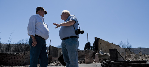Michael Mangum  |  Special to the Tribune

Indianola resident Dave Taylor, left, and independent insurance adjuster Jeff Selmos discuss insurance claims in front of what is left of Taylor's home on Wednesday, June 27, 2012. The Wood Hollow wildfire ripped through the area earlier in the week, destroying everything on Taylor's property.