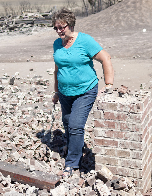 Michael Mangum  |  Special to the Tribune

Indianola resident Janice Taylor walks through the rubble of her home on Wednesday, June 27, 2012. Taylor's home had been completely destroyed when the Wood Hollow wildfire ripped through the area, destroying everything on her property.