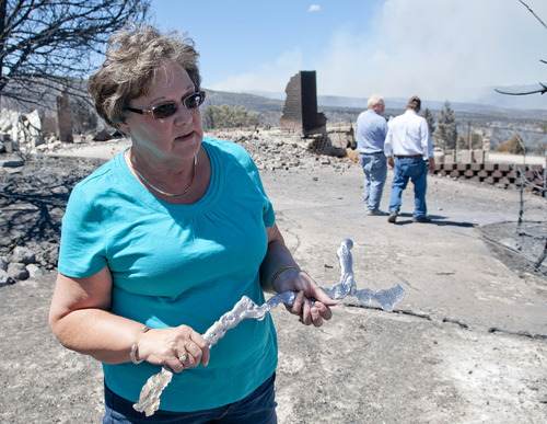 Michael Mangum  |  Special to the Tribune

With smoke from the Wood Hollow wildfire still billowing in the background, Indianola resident Janice Taylor reacts as she walks through her property after flames completely engulfed and destroyed her home and everything on the property on Wednesday, June 27, 2012.