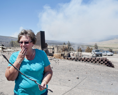 Michael Mangum  |  Special to the Tribune

With smoke from the Wood Hollow wildfire still billowing in the background, Indianola resident Janice Taylor reacts as she walks through her property after flames completely engulfed and destroyed her home and everything on the property on Wednesday, June 27, 2012.