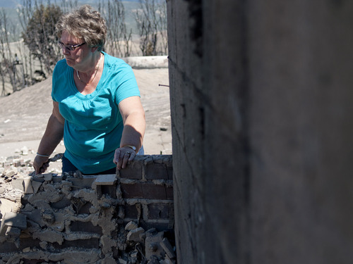 Michael Mangum  |  Special to the Tribune

Indianola resident Janice Taylor surverys the rubble of her home on Wednesday, June 27, 2012. Taylor's home had been completely destroyed when the Wood Hollow wildfire ripped through the area, destroying everything on her property.