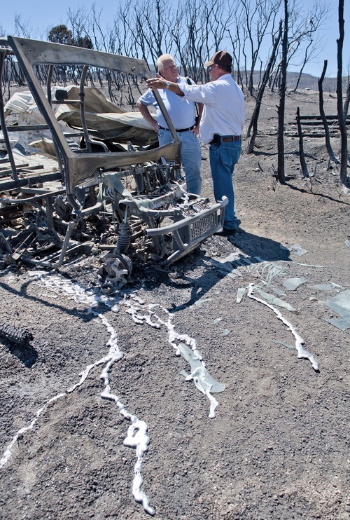 Michael Mangum  |  Special to the Tribune

Independent insurance adjuster Jeff Selmos, left, and Indianola resident Dave Taylor survey the damage done to Taylor's property in Indianola, Sanpete county on Wednesday, June 27, 2012 after the Wood Hollow wildfire ripped through the area earlier in the week. Streams of molten aluminum are shown draining away from Taylor's Ranger 4-wheeler.