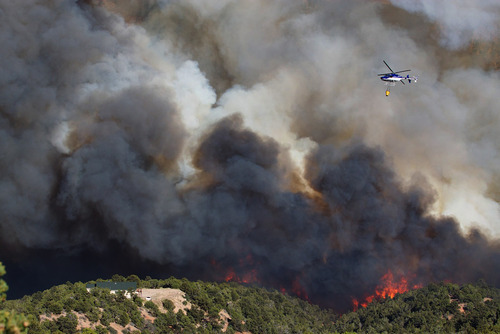 Kyle Kester  |  Special to The Salt Lake Tribune

A helicopter prepares to drop water on a wild fire burning near a home in New Harmony, Utah, Wednesday, June 27, 2012.
