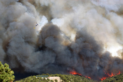 Kyle Kester  |  Special to The Salt Lake Tribune

A helicopter prepares to drop water on a wild fire burning near a home in New Harmony, Utah, Wednesday, June 27, 2012.