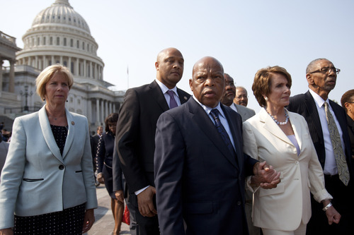 Rep. John Lewis, D-Ga., center, holds hands with House Minority Leader Nancy Pelosi of Calif., next to Rep. Bobby Rush, D-Ill., right, as House Democrats leave the Capitol in protest of a House vote to hold Attorney General Eric Holder in contempt of Congress, Thursday, June 28, 2012, on Capitol Hill in Washington. (AP Photo/Jacquelyn Martin)