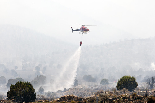 Christopher Reeves  |  Special to The Salt Lake Tribune

A helicopter fights the fire near Saratoga Springs and Eagle Mountain on Friday, June 22, 2012.