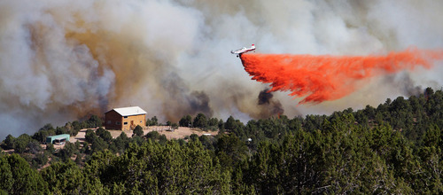 Kyle Kester  |  Special to The Salt Lake Tribune

A plane drops fire retardant near a home in New Harmony on Wednesday, June 27, 2012.