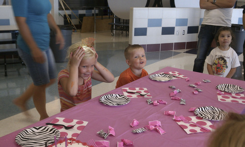 Cimaron Neugebauer | The Salt Lake Tribune
Annie Carlson, 6, of Herriman smiles as she gets ready to blow out the candles on her birthday cake in the cafeteria of Herriman High School -- the Rose Crest Fire evacuation center -- on Saturday.