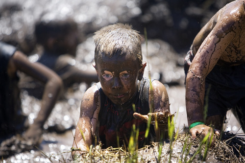 Kim Raff | The Salt Lake Tribune
Kids climb a mud obstacle during the Kids Fit Junior Spartan Race at Soldier Hollow in Midway on Saturday, June 30, 2012.