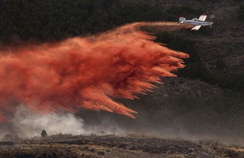 Jeremy Harmon  |  The Salt Lake Tribune

A plane dumps retardant on the fire in the foothills above Herriman on Friday, June 29, 2012.