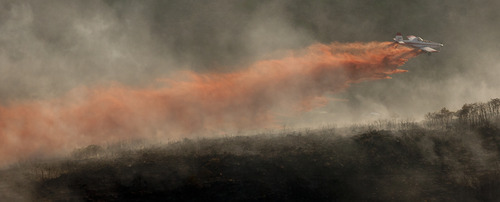 Jeremy Harmon  |  The Salt Lake Tribune

A plane dumps retardant on the fire in the foothills above Herriman on Friday, June 29, 2012.