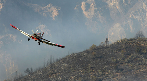 Steve Griffin | The Salt Lake Tribune
A plane pulls up after dropping its payload of fire retardant as fire burns in the mountains near Alpine on Tuesday July 3, 2012.