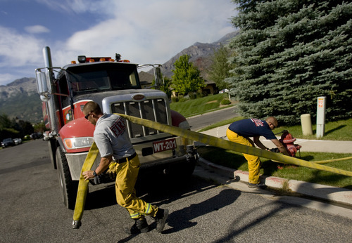 Kim Raff | The Salt Lake Tribune
(left) Mike Stevens and Dustin Mitchell, both from Lone Peak Fire, fill up a pumper truck with water to help contain the Quail Wildfire that is burning in the hills above Alpine, Utah on July 4, 2012.