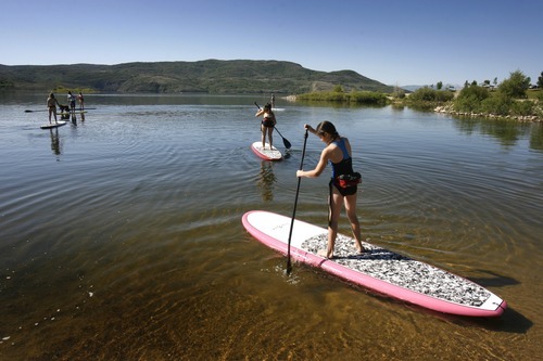 Rick Egan  | The Salt Lake Tribune 

Rebecca Hale,11,  (right) paddles out into the water, along with her sisters, during their  stand up paddle boarding lesson at Jordanelle Reservoir, Thursday, June 14, 2012.