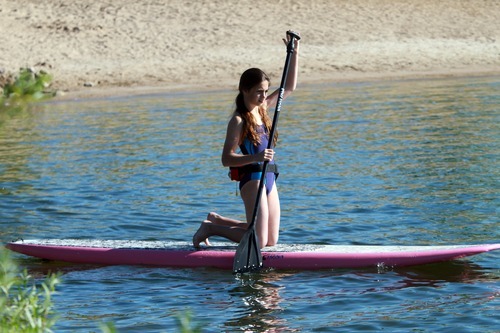 Rick Egan  | The Salt Lake Tribune 

Rebecca Hale, 11,  paddles on her knees as she gets her balance, during a paddle boarding lesson at Jordanelle Reservoir, Thursday, June 14, 2012.