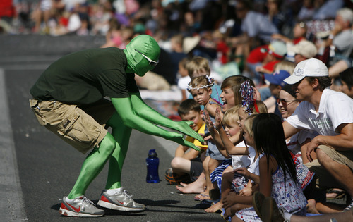 Francisco Kjolseth  |  The Salt Lake Tribune
Utah Valley University green man gets high fives from the thousands lining the streets of downtown Provo to watch the Freedom Festival Parade on Wednesday, July 4, 2012.