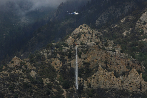 Scott Sommerdorf  |  The Salt Lake Tribune             
After the cloud cover started to clear and the rain stopped, a helicopter dropped water on hotspots of the Quail Fire in Alpine, Thursday, July 5, 2012.