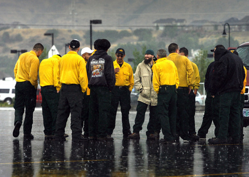 Rick Egan  | The Salt Lake Tribune 

Fire crews wait out the rain at Line Peak High School, Thursday, July 5, 2012.  The rain may have slowed the fire down a little bit but it hampered the work of the fire fighters on the ground as well as work of the airplanes and helicopters, due to the poor visibility during the rain storm this morning.