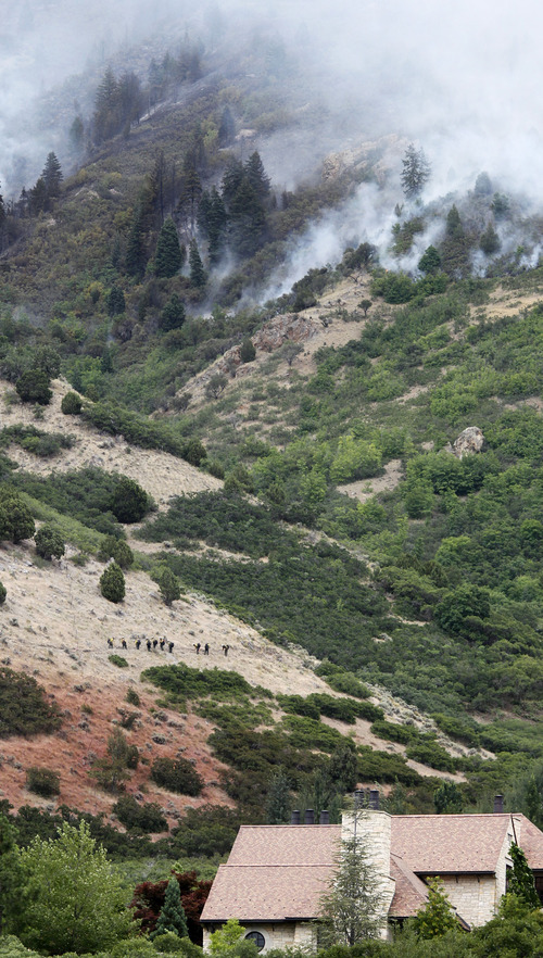 Al Hartmann  |  The Salt Lake Tribune  
Hand crews cuts a line on side of mountain to fight fire above Alpine near Country Manor Lane and 300 North Thursday July 5.  The fire laid down last night with the cooler more humid weather.  A light rain was falling at 9:30.