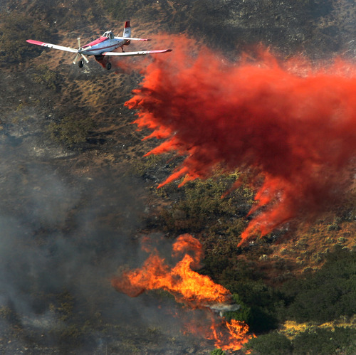 Steve Griffin | The Salt Lake Tribune
A plane drops its payload of fire retardant on a fire that burns in the mountains near Alpine on Tuesday July 3, 2012.