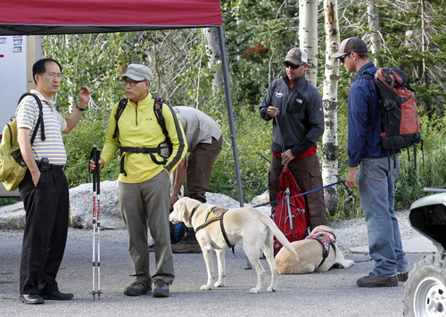 Al Hartmann  |  The Salt Lake Tribune  
Family members of Oknom Shim Han wait at command center at White Pine trailhead in Little Cottonwood Canyon on Wednesday, July 11 as Salt Lake County Unified Police Department search and rescue and SWAT team members gather to resume their search. Han was found alive and well later Wednesday.