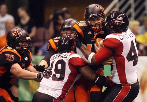 Kim Raff | The Salt Lake Tribune
Utah Blaze quarterback Tommy Grady is sacked by Cleveland Gladiators players (left) Tim Cheatwood and Jarrett Crittenton during a game at the EnergySolutions Arena in Salt Lake City, Utah on July 13, 2012.