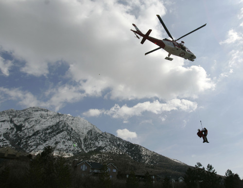 Jim Urquhart | Tribune file photo
Search-and-rescue workers are airlifted by helicopter in April 2009 to Mount Olympus to assist in a rescue operation. A woman hiker fell 1,000 feet to her death into a snow-filled ravine on Mount Olympus. Her son and another 14-year-old boy survived.
