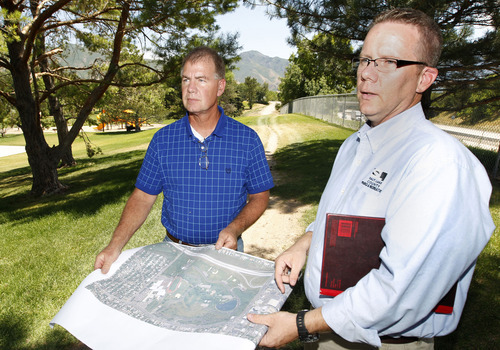 Al Hartmann  |  The Salt Lake Tribune  
Parleys Trail project manager Walt Gilmore, left, and Salt Lake County Parks spokesman Martin Jensen look over an aerial map of Sugar House Park where the route is planned. The trail enters the park behind them at 1700 East near Interstate 80, where its design required fill dirt to modify a steep slope and the removal of 30 trees.