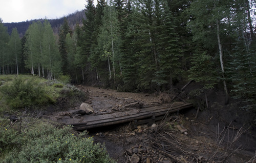 Kim Raff | The Salt Lake Tribune
A foot bridge is almost completely covered by a debris slide caused by unstable ground from the Seeley Fire in the Old Folks Campground in Carbon County, Utah, on July 15, 2012.  After a serious forest fire the ground in the burned area becomes unstable and can cause large debris slides.