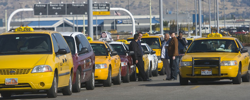 Al Hartmann  |  The Salt Lake Tribune
Taxi drivers queue up for fares south of Salt Lake City International Airport on Thursday. Two local cab companies were passed over for contracting for on-demand services to two out-of-state firms.
